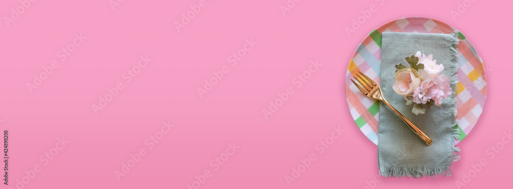 Colorful pastel place setting on pink background with space for copy