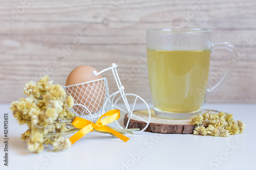 One of the symbols of Easter, Macela (achyroclien satureioides), a medicinal tea traditionally harvested before sunrise on Good Friday. Served in a glass cup, a bouquet of tea flower and an egg. photo