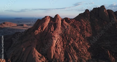 4K sunrise aerial footage of savanna, famous red granite Spitzkoppe Peak and Pontok Mountains in central Namibia between interior town Usakos and Atlantic west coast, southern Africa