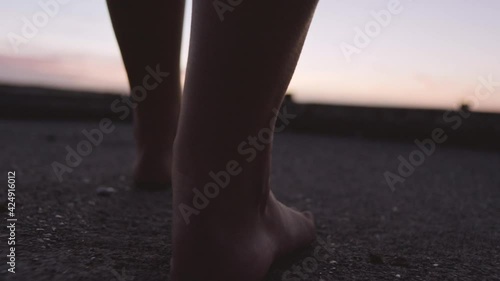 Barefoot Woman Walking Towards Harbour At Sunset