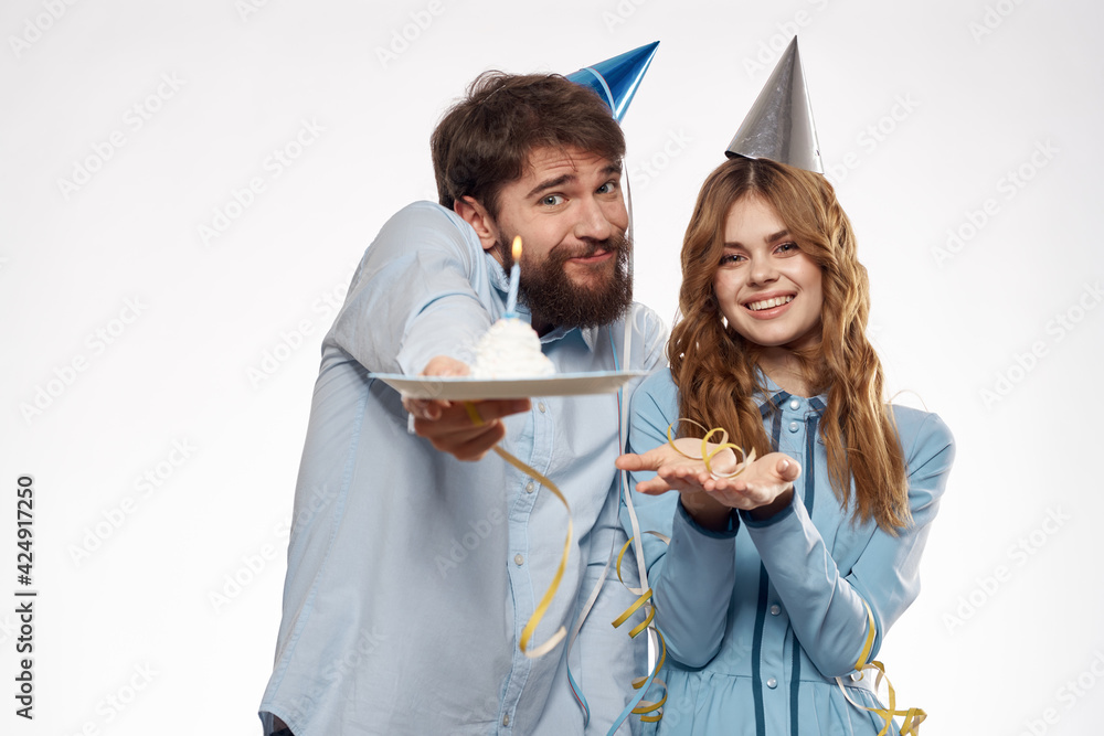 Joyful man and cheerful Woman holiday cake Birthday cap party corporate party young people Joyful man and cheerful Woman holiday cake Birthday cap party corporate party young people