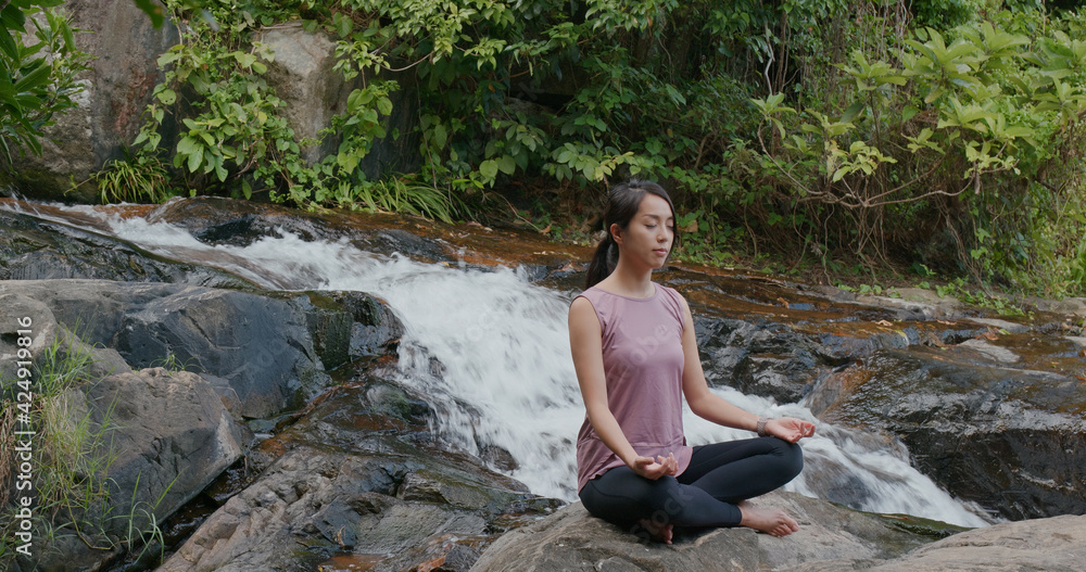 Woman do yoga with the waterfall background at waterfall Woman do yoga with the waterfall background at waterfall