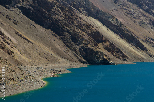 The turquoise color water laker high in the Andes cordillera. The glacier water lake called Inca Lagoon and arid mountains in Portillo, Chile.