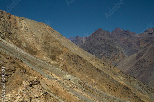 The Andes mountain range. View of the arid rocky mountains beautiful color and texture, under a blue sky. 