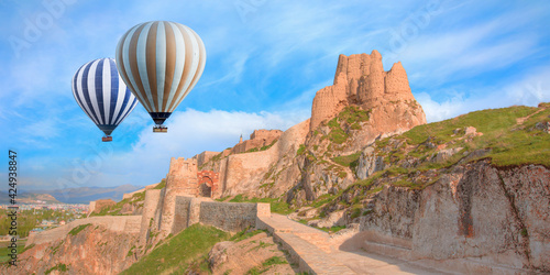 Hot air balloon flying over Ruins of ancient fortress in Van - The old castle of Van - Van, Turkey