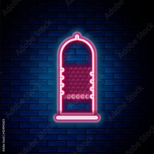 Glowing neon line Condom safe sex icon isolated on brick wall background. Safe love symbol. Contraceptive method for male. Colorful outline concept. Vector