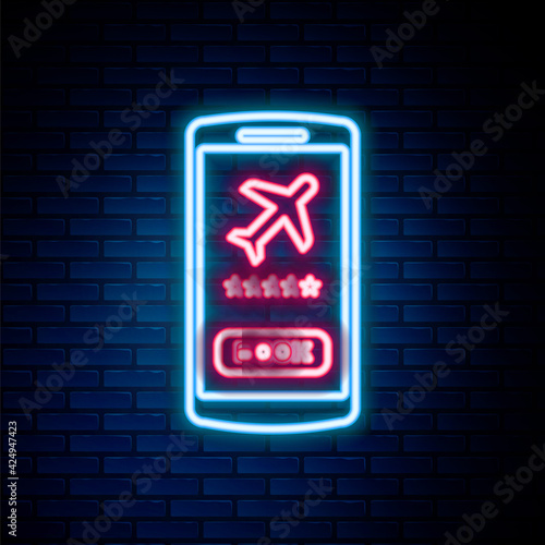 Glowing neon line Smartphone with electronic boarding pass airline ticket icon isolated on brick wall background. Passenger plane mobile ticket for web and app. Colorful outline concept. Vector