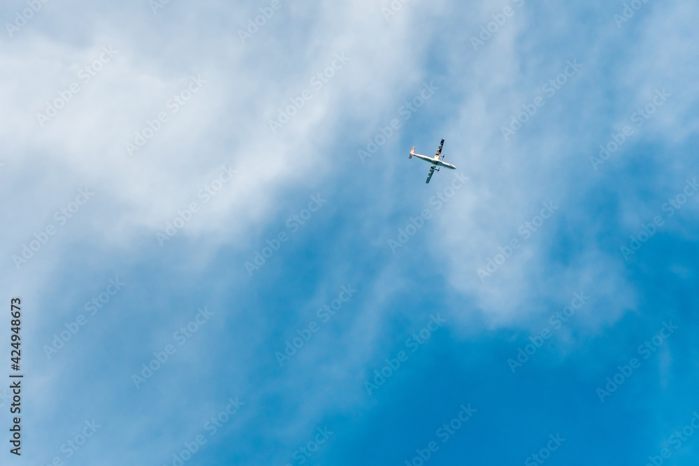 a small silhouette of an airplane in a blue sky with white clouds a small silhouette of an airplane in a blue sky with white clouds