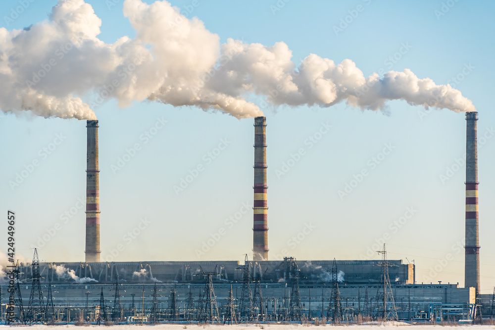 Smoking factory chimneys.Environmental problem of pollution of environment and air in large cities.Climate change,ecology and global warming.The sky is smoky with toxic substances.Soot from factories