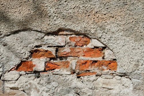 Alte Mauer mit abgebröckeltem Putz wo die Ziegel herausschauen