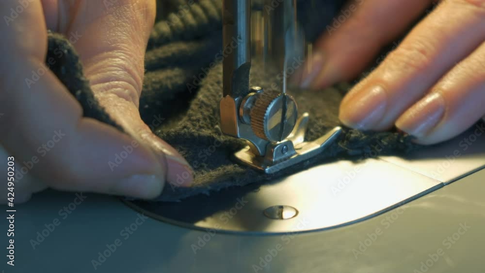 A seamstress works on a sewing machine, sewing clothes A seamstress works on a sewing machine, sewing clothes