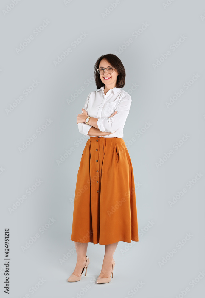 Full length portrait of mature businesswoman on light grey background Full length portrait of mature businesswoman on light grey background
