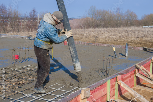 Builder pouring the foundation of a country house photo