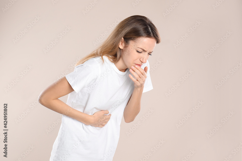 Woman suffering from nausea on beige background. Food poisoning Woman suffering from nausea on beige background. Food poisoning