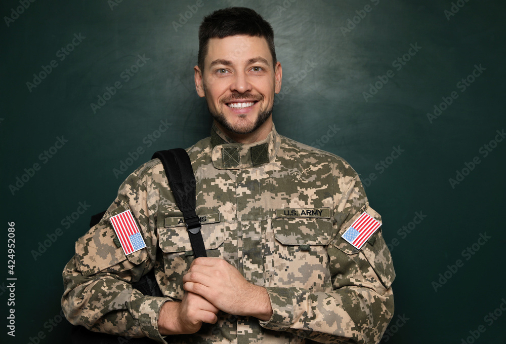 Cadet with backpack near chalkboard. Military education