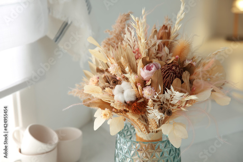 Fototapeta Naklejka Na Ścianę i Meble -  Bouquet of dry flowers and leaves on countertop in kitchen