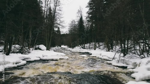 Flying drone over rapids in Spring time. Beautiful artistic ice and snow formations made by nature. The rapids is located in Nurmijärvi, Finland. It is called Nukarinkoski. photo