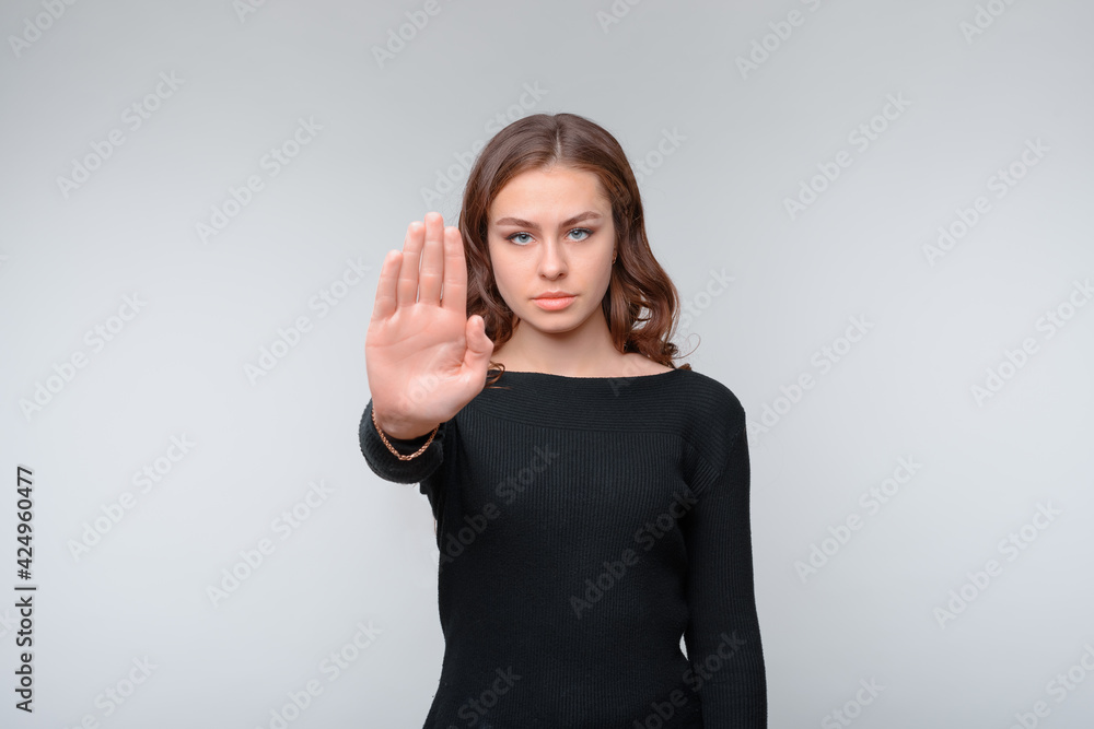 Stop sign, palm on camera, symbol - donT move. Serious young brunette woman shows her palm right on camera Stop sign, palm on camera, symbol - donT move. Serious young brunette woman shows her palm right on camera