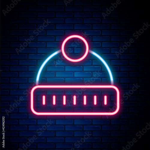 Glowing neon line Winter hat icon isolated on brick wall background. Colorful outline concept. Vector