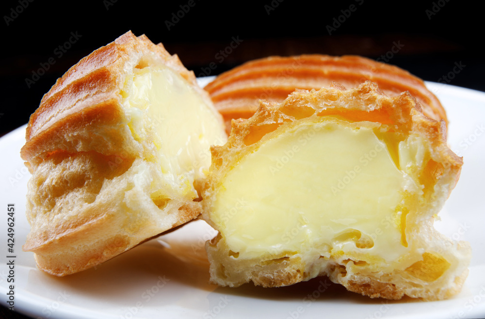 Two halves of eclair on a white plate . Two halves of eclair on a white plate .