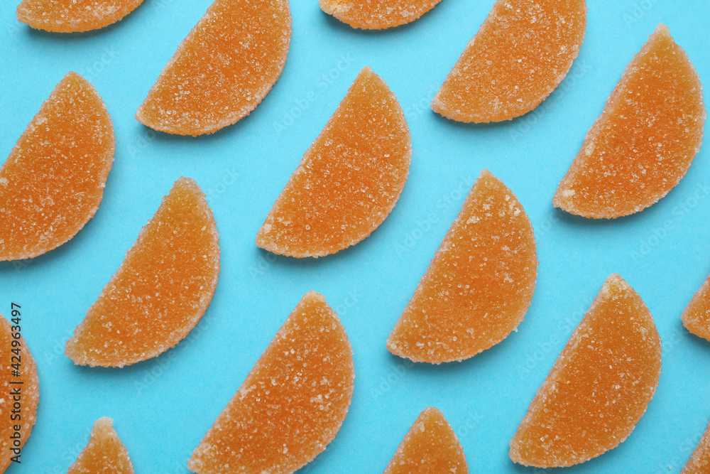Delicious orange marmalade candies on light blue background, flat lay Delicious orange marmalade candies on light blue background, flat lay