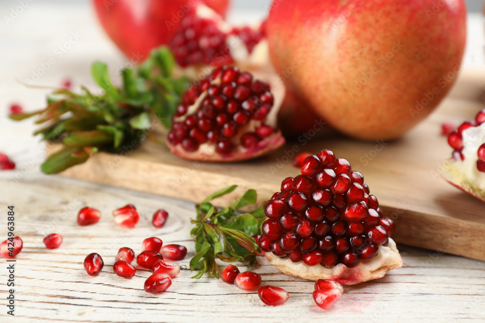 Delicious ripe pomegranates on white wooden table, closeup Delicious ripe pomegranates on white wooden table, closeup