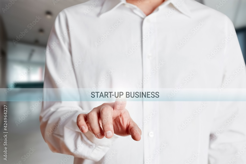 Fototapeta premium Businessman presses start up business button on a virtual screen.