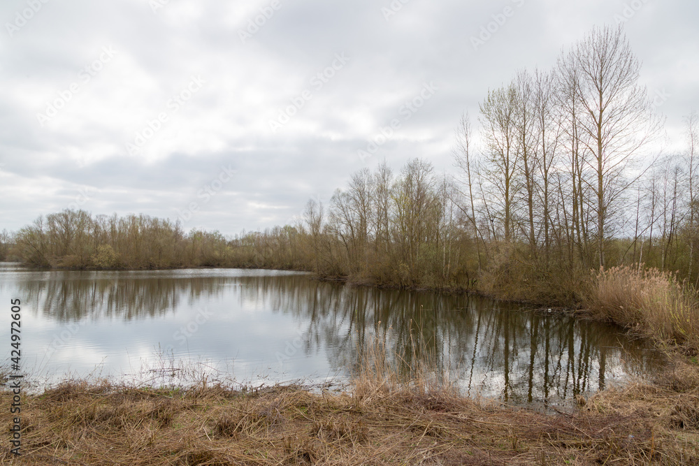 Landschaft in der Lahnaue bei Heuchelheim in Hessen mit Bäumen, die sich im Wasser spiegeln Landschaft in der Lahnaue bei Heuchelheim in Hessen mit Bäumen, die sich im Wasser spiegeln