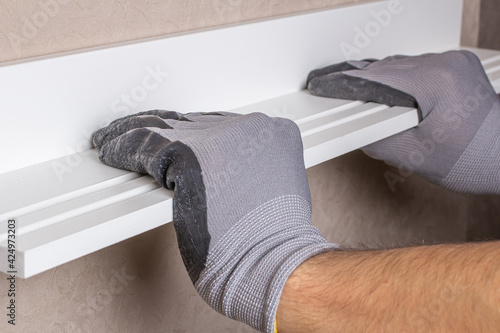 alignment of the hanging shelf with the level of the gloved worker