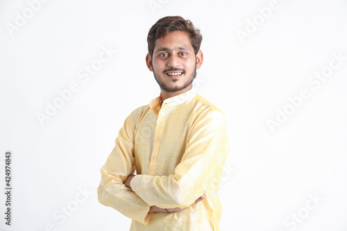 Young indian man in tradition wear and standing on white background. © Niks Ads