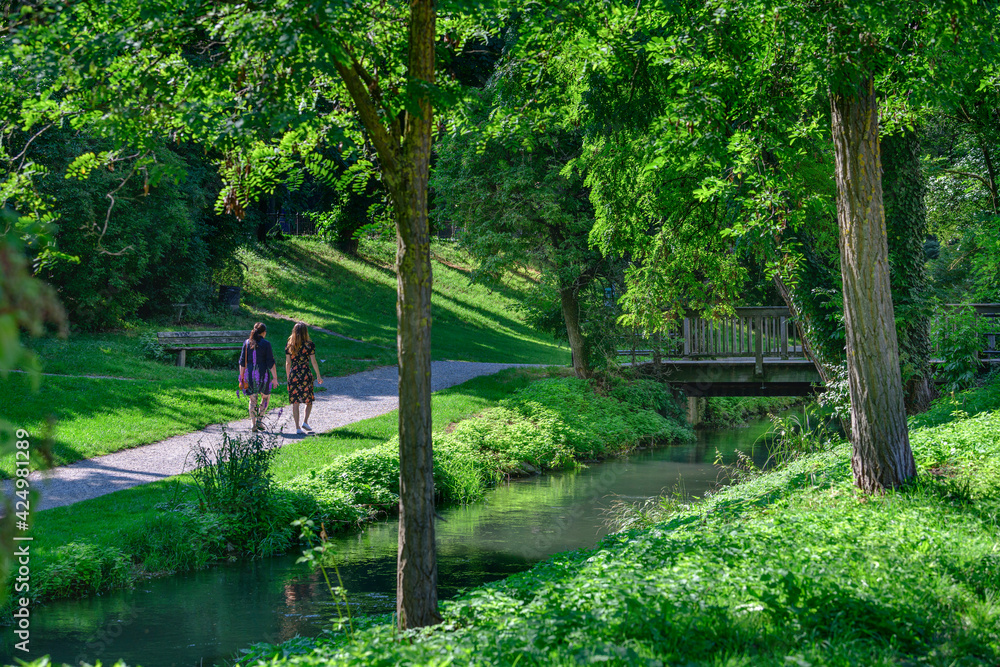 Spaziergänger in einer grünen Oase in der altstadt von Augsburg