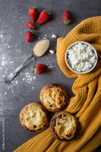 Authentic Russian open pies made of cottage cheese. Vatrushka - Traditional Russian open pie with cottage cheese. Sweet breakfast recipes.  Yellow fabric background. Sunny day photo. 