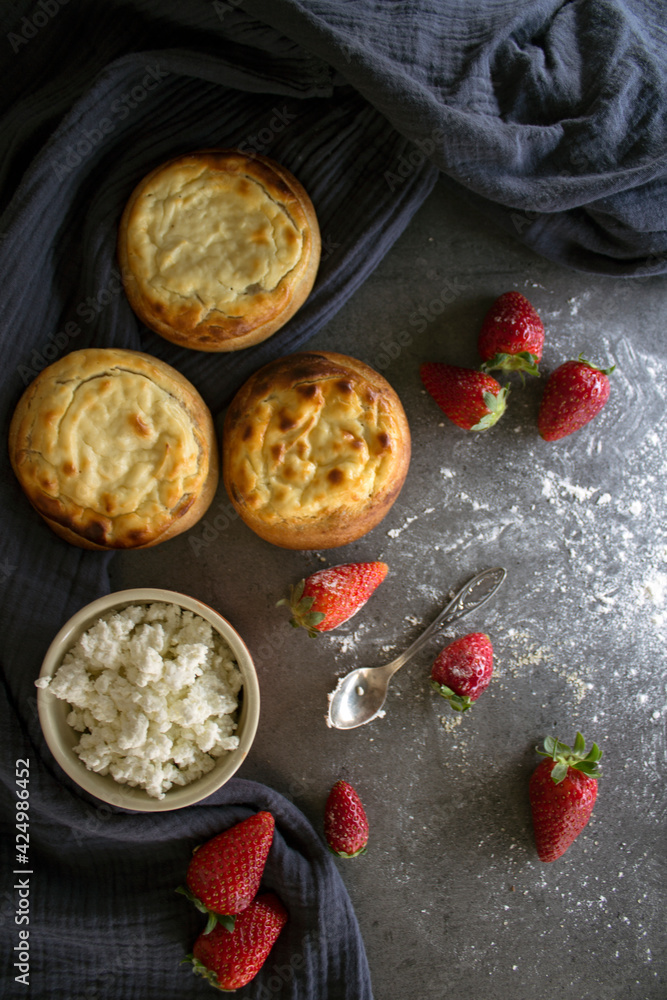 Round scones with cottage cheese on a table. Russian homemade pastry items. Sweet buns top view photo.