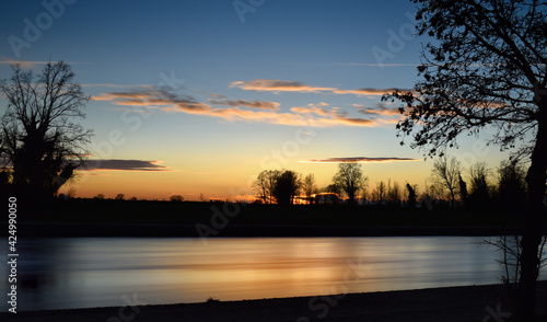 incredible sunset on the Muzza river, lights, colors and reflections surround this breathtaking landscape