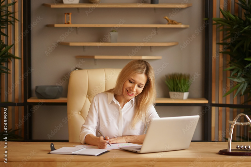 A beautiful businesswoman in a white shirt sits on the chair at the office. Confident woman concept A beautiful businesswoman in a white shirt sits on the chair at the office. Confident woman concept
