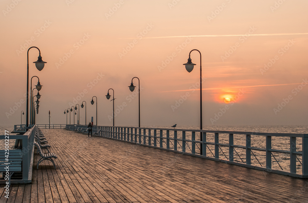 Obraz premium o wschodzie na molo 1