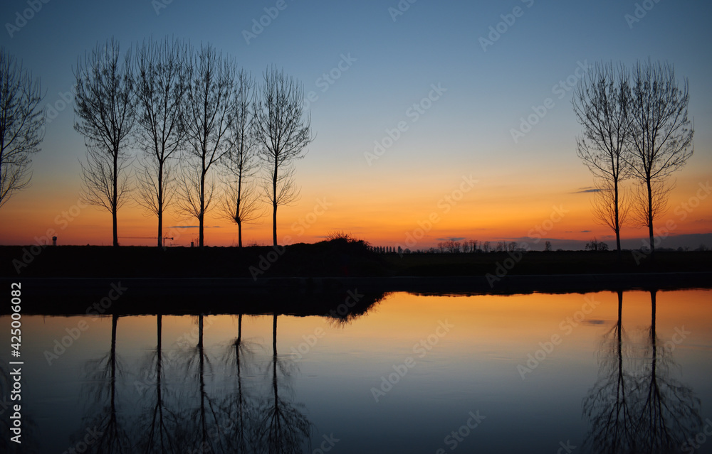 incredible sunset on the Muzza river, lights, colors and reflections surround this breathtaking landscape