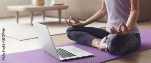 Young woman practicing yoga at home panoramic banner, online video training, Girl doing exercises and meditate, Yoga, balance, meditation, relaxation, healthy lifestyle, online training class concept © kite_rin