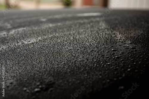 Roof of a black car in the rain, side view