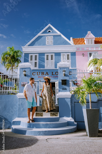 Curacao, Netherlands Antilles View of colorful buildings of downtown Willemstad Curacao Colorful restored colonial buildings in Pietermaai, couple men and woman mid age posing by colorful buildings photo