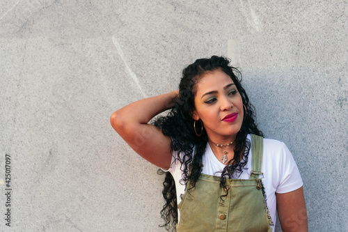 Portrait of a beautiful woman leaning against a wall