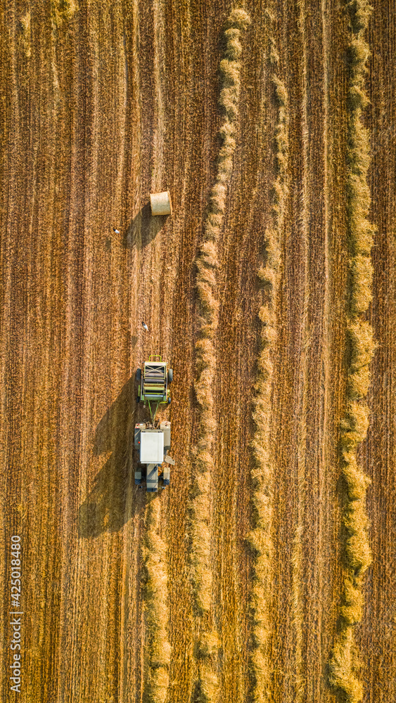 Tractor pressing hay. Agriculture in Poland. Harvest in summer Tractor pressing hay. Agriculture in Poland. Harvest in summer