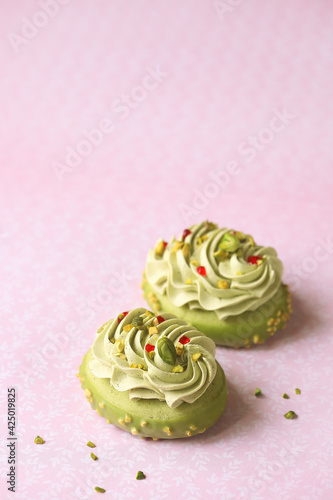Pistachio Shortbread Cakes with Pistachio Pastry Cream and Raspberry Jam, on a light pink background.