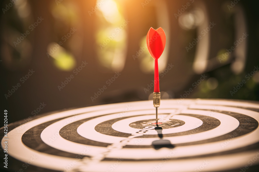 Close-up the bullseye or bulls eye target or dart board has dart arrow throw hitting the center of a shooting for business targeting and aim to winning goals concepts Close-up the bullseye or bulls eye target or dart board has dart arrow throw hitting the center of a shooting for business targeting and aim to winning goals concepts