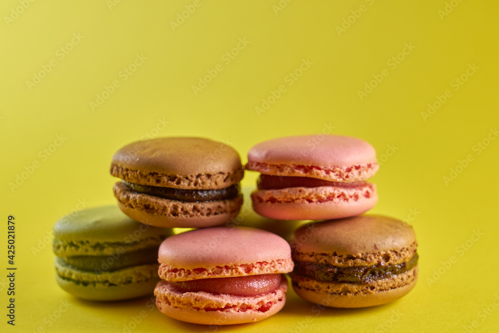Fototapeta premium Cake macaron close up on yellow background flavor almond cookies pastel colors.