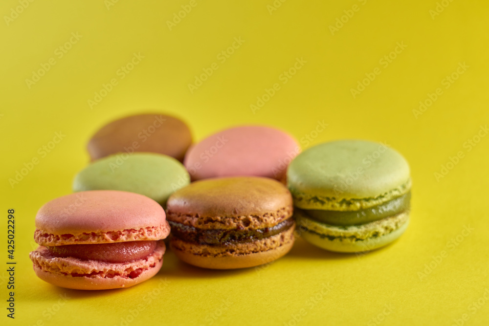 Cake macaron close up on yellow background flavor almond cookies pastel colors. Cake macaron close up on yellow background flavor almond cookies pastel colors.