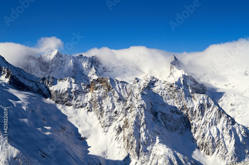 Beautiful snowy mountains and blue sky Dombay Karachay-Cherkessia.