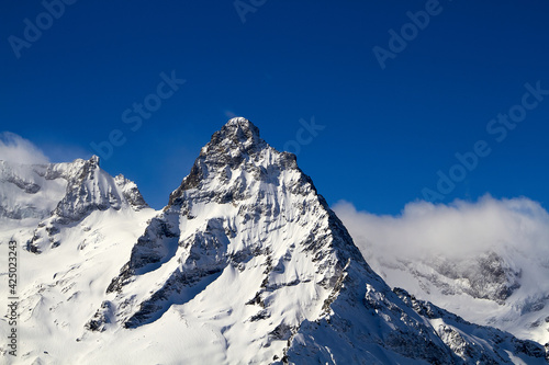 Beautiful snowy mountains and blue sky Dombay Karachay-Cherkessia.