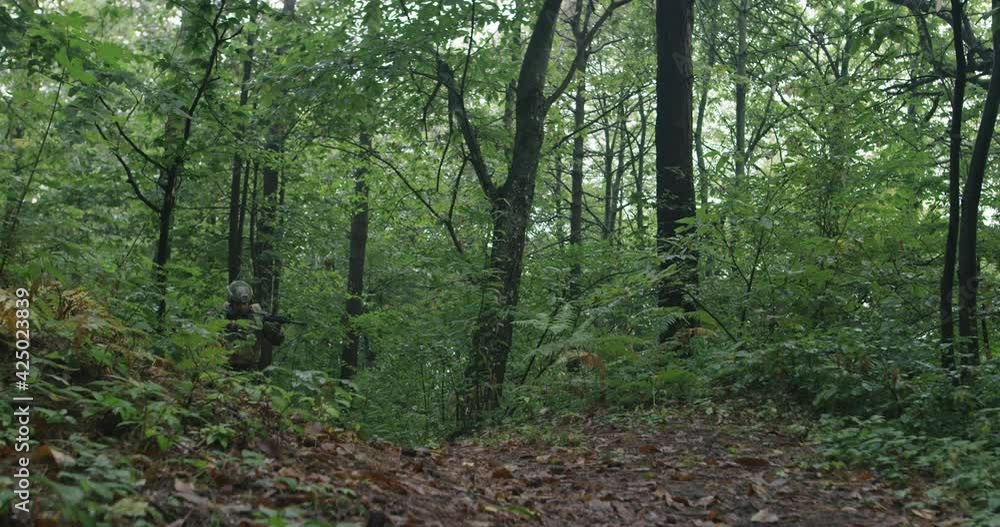 Soldiers moving through forest during tactical action concept of war and attacking Soldiers moving through forest during tactical action concept of war and attacking