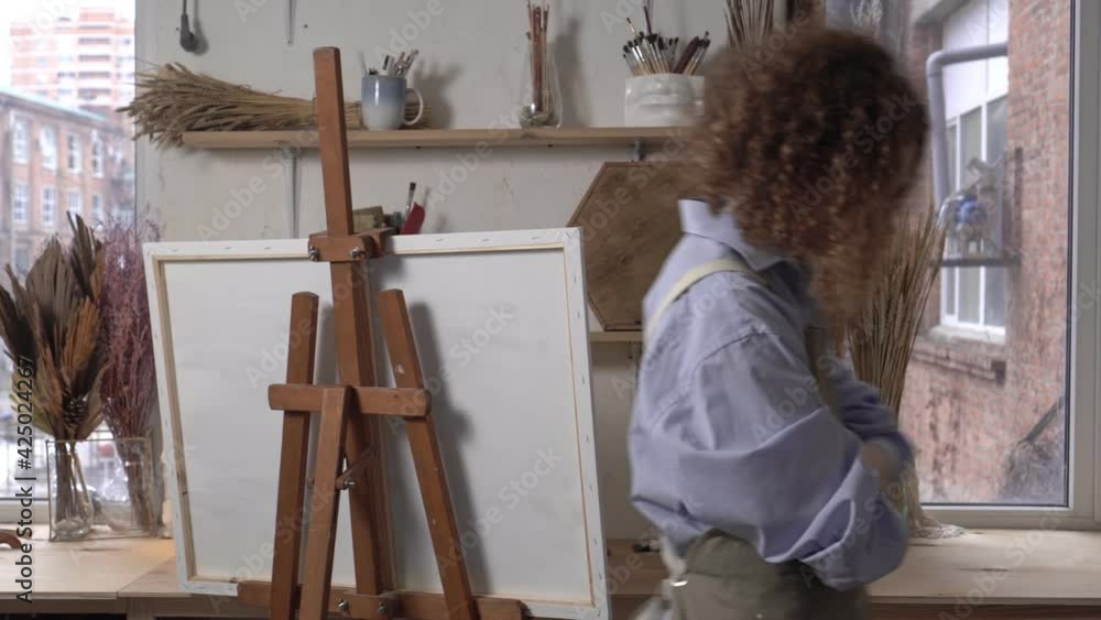 An artist in a creative crisis awaits inspiration. Unhappy sad woman artist in the studio An artist in a creative crisis awaits inspiration. Unhappy sad woman artist in the studio